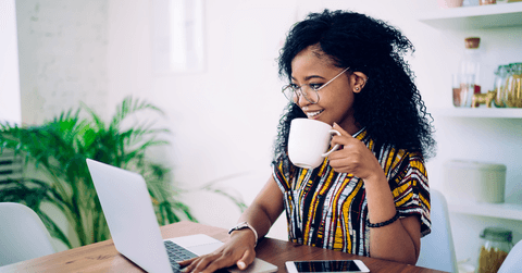 Woman with coffee working on laptop