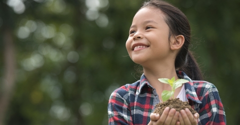 Asian child holding a plant