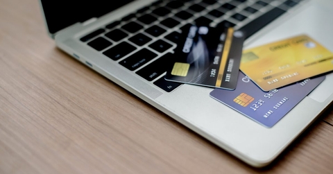 Three credit cards spread out on a laptop keyboard