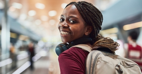 a woman in an airport looking back and smiling
