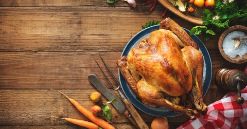 A roasted turkey on a wooden tabletop. 