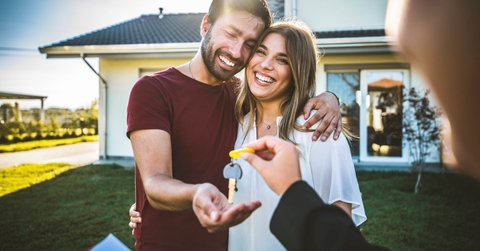 A happy couple renting a house and receiving their key