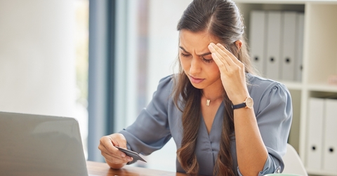 Stressed woman looking at credit card