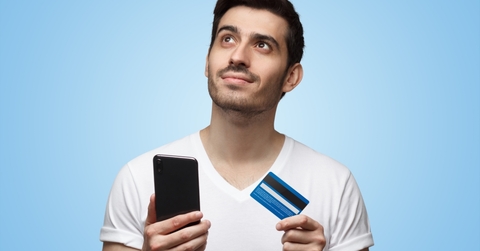 An adult man thinking about applying for a credit card