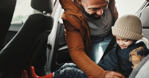 A father is keeping his child safe by using a seat belt