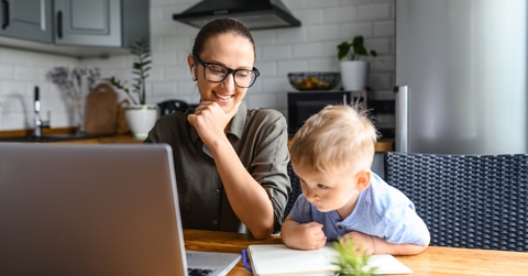 Woman working at table with a toddler