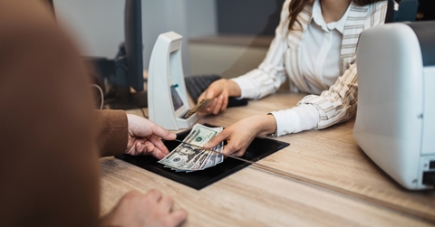 A man receiving money from a bank teller