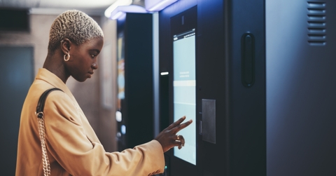 An adult woman using an ATM