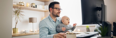Young father working from home and babysitting his baby boy in the same time.