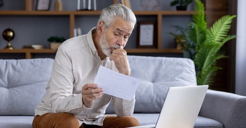 upset senior man reviewing bills