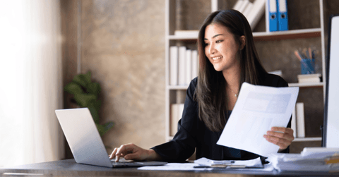 A woman works on her computer. 