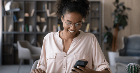 A woman looks at her phone at home. 