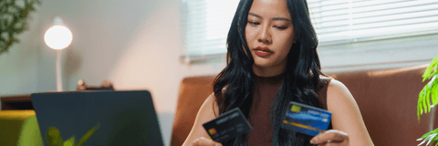 Woman looking at two credit cards