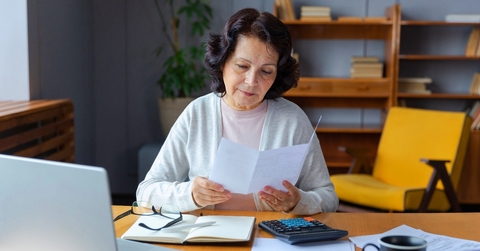 Older woman doing paperwork in her home office