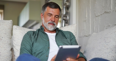 Man on the couch looking at tablet