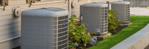 A row of new air conditioning units behind townhomes