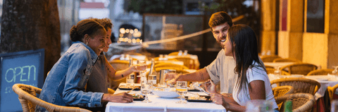Friends enjoying dinner on restaurant patio