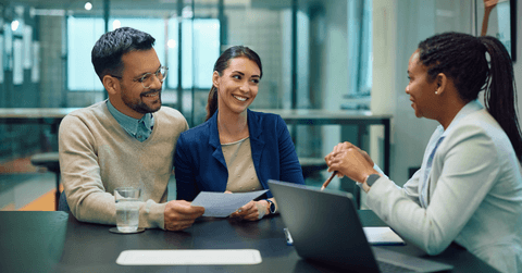 Young couple sitting with financial advisor at bank