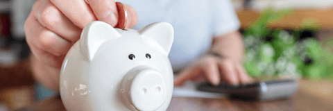 Man putting coins in piggy bank