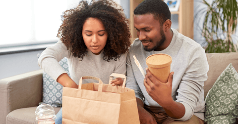 Couple eating takeout food at home