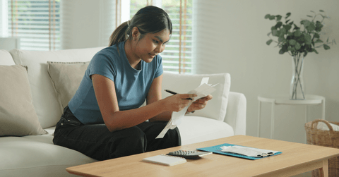 Young woman going over receipts to save money