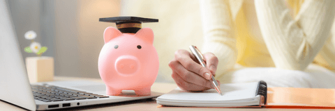 Woman playing tuition savings with piggy bank and laptop