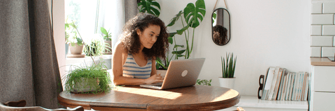 Woman at home checking banking on laptop