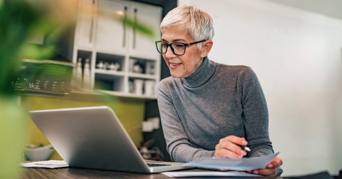 retired woman working at laptop on side hustle