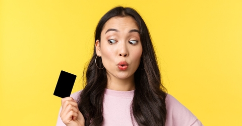 girl looking amused at credit card