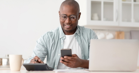 Man using phone and calculator