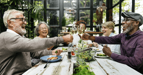 Happy retired friends eating together