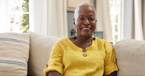smiling senior woman sitting on sofa at home