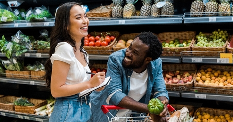 happy african american man looking at asian woman with notebook 