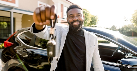cheerful young African man smiling showing car keys 