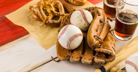 Baseballs and glove next to pretzels and beer