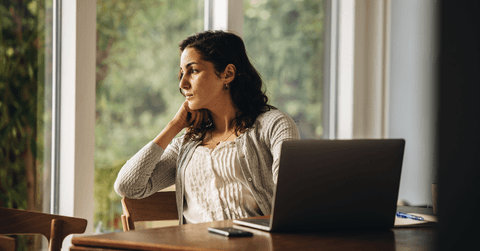 Woman looking out of window at home