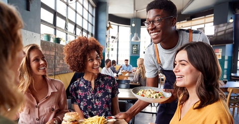 waiter serving group of female friends