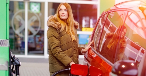 young caucasian woman at self-service gas station refueling the car