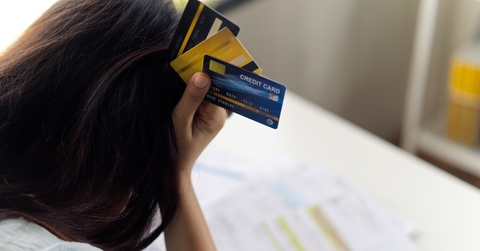 Woman stressed holding credit cards