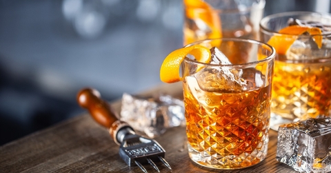 old fashioned classic rum cocktail on ice with orange zest garnish