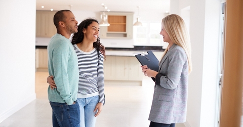 female realtor showing couple interested in buying around house