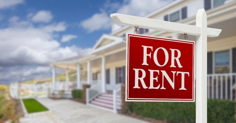 for rent real estate sign in front of house