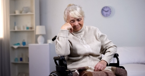 depressed aged lady in wheelchair thinking about health problems at hospital