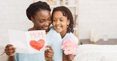 Daughter giving her mother flowers and card on Mother&#x27;s Day
