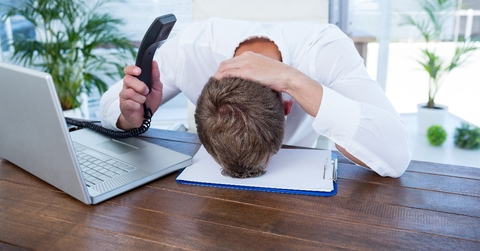 irritated businessman holding a land line phone