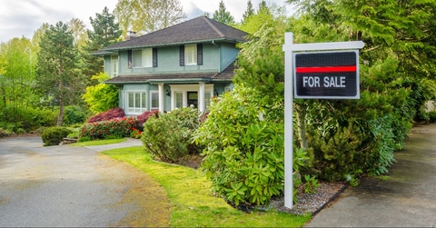 house for sale real estate sign in front of a house