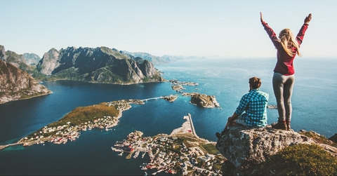 couple family traveling together on cliff edge in Norway
