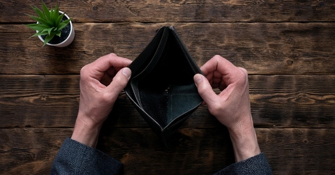 empty wallet in hands on an office table 