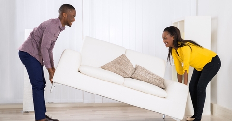 couple placing sofa in living room