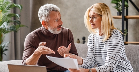 upset middle aged couple with laptop